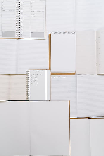 A minimalist flat lay of blank and spiral notebooks arranged neatly on a desk, perfect for office or school themes. HD phone wallpaper