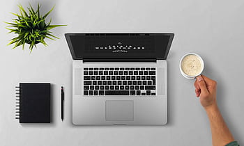 Minimalist workspace with a laptop, notebook, and coffee cup on a grey desk. HD wallpaper