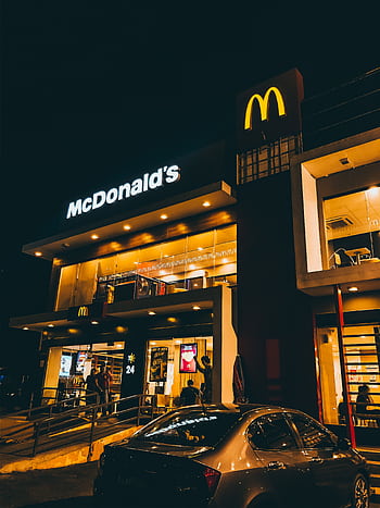 Exterior view of McDonald's in Cauayan City, Philippines illuminated at night with cars and people. HD phone wallpaper