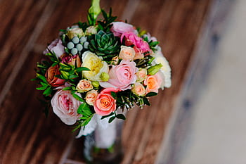 A top-view of a beautiful bouquet featuring roses, succulents, and greenery, perfect for weddings or celebrations. HD wallpaper