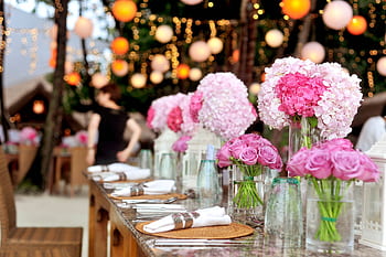 Elegant outdoor wedding setup featuring pink floral arrangements and soft lighting. HD wallpaper