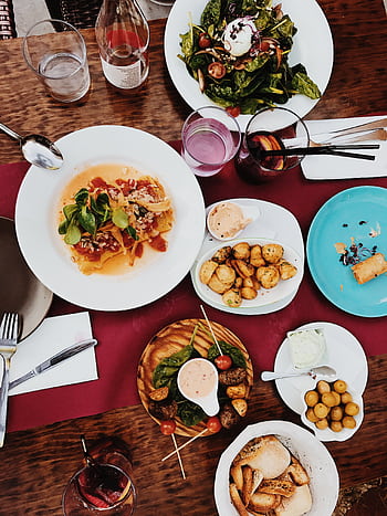 A colorful spread of gourmet dishes on a classy dinner table setting. HD phone wallpaper