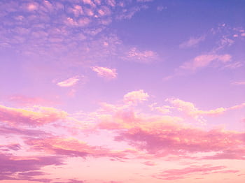 A dreamy pink and purple cloud-filled sky at sunset, creating a serene and tranquil atmosphere. HD wallpaper