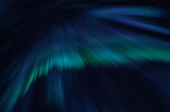 Breathtaking view of the aurora borealis illuminating the starry night sky with vibrant green and blue hues. HD wallpaper