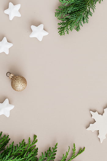 Festive Christmas flat lay with stars, ornaments, and greenery on a neutral background. HD phone wallpaper