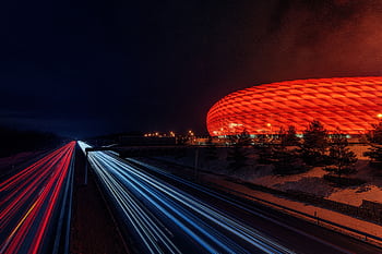 Capture of Allianz Arena illuminated at night with dynamic light trails. HD wallpaper