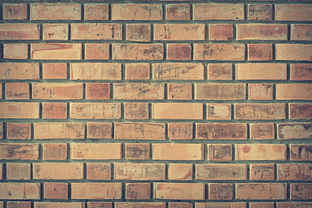 A vintage brick wall texture featuring weathered red bricks, ideal for background or use. HD wallpaper