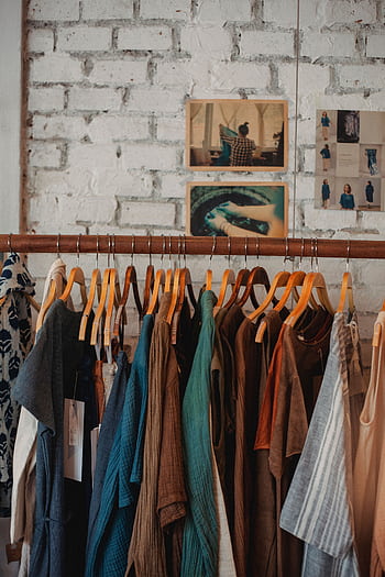 Colorful assortment of clothes on wooden hangers in a trendy boutique. HD phone wallpaper