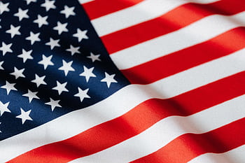 A detailed close-up of the American flag, showcasing its stars and stripes with a vibrant, wavy texture. HD wallpaper