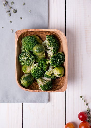 Fresh broccoli and Brussels sprouts in a wooden bowl on light wooden surface. HD phone wallpaper