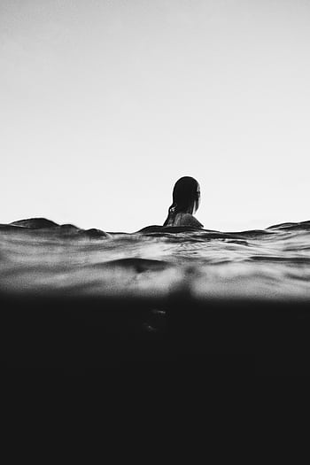 Artistic black and white of a woman swimming at dusk, creating a serene and adventurous mood. HD phone wallpaper