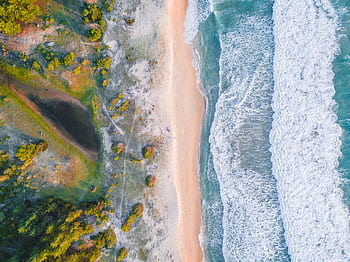 Bright and vibrant aerial view of a coastline in Aceh, Indonesia with waves crashing on a sandy beach. HD wallpaper