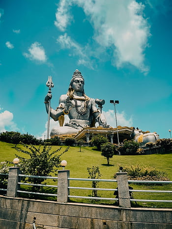 Grand Shiva statue surrounded by greenery under blue sky, ideal for travel and cultural themes. HD phone wallpaper