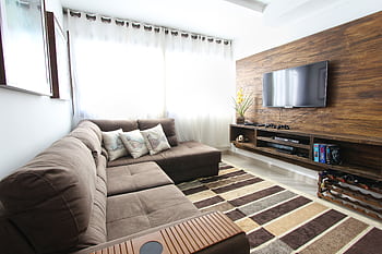 Stylish modern living room featuring a brown sofa, wall-mounted TV, and interior decor. HD wallpaper