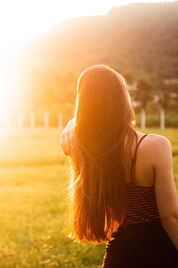 A young woman with long hair enjoys the sunset in a field near Rio do Sul, Brazil. HD phone wallpaper