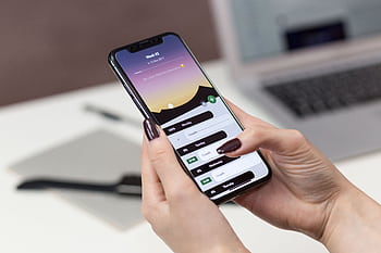 A woman interacts with a productivity app on her smart at a desk setup. HD wallpaper