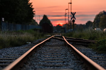 Captivating sunset scene over railway tracks in Norra Skara, Sweden. Perfect for travel and transportation themes. HD wallpaper