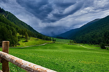 Beautiful green valley under cloudy skies in Schlinig, Trentino-Südtirol, Italy. HD wallpaper