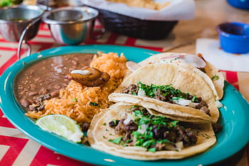 Mouth-watering Mexican tacos served with rice and beans, garnished with cilantro and lime. HD wallpaper