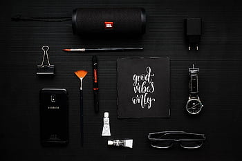 Creative flat lay of modern gadgets and art supplies on a dark surface, conveying a mood of style and inspiration. HD wallpaper