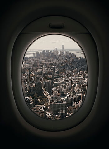View of Manhattan skyline from an airplane window, showcasing urban architecture and iconic skyscrapers. HD phone wallpaper