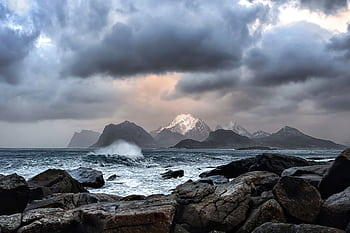 A powerful storm brews over the rugged Lofoten coastline, capturing Norway's dramatic natural beauty. HD wallpaper