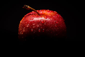 Close-up of a fresh red apple with water droplets against a dark background. HD wallpaper
