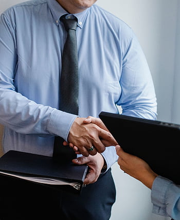 Business handshake between colleagues in a formal office meeting setting. HD phone wallpaper