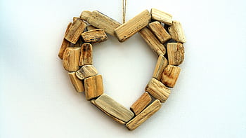 Heart-shaped craft made from rustic wooden pieces, symbolizing love and nature. HD wallpaper