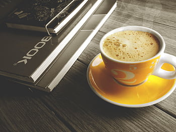A warm cup of coffee on a yellow saucer beside a stack of books, perfect for a relaxing break. HD wallpaper