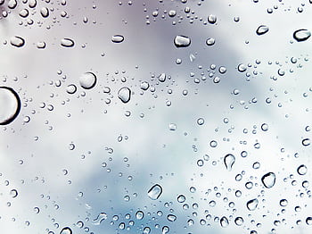 Raindrops on a window against a cloudy sky, creating a peaceful mood. HD wallpaper