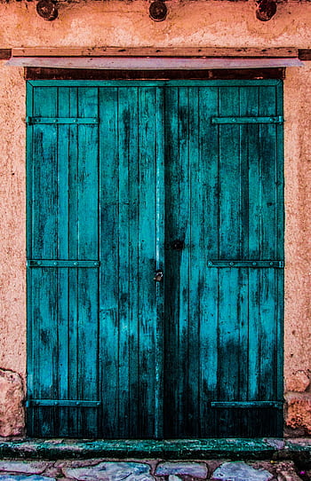 A vibrant, rustic blue wooden door on a textured, weathered wall. HD phone wallpaper