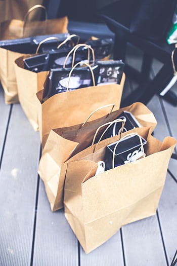 A collection of brown paper bags filled with shopping items, perfect for retail themes. HD phone wallpaper
