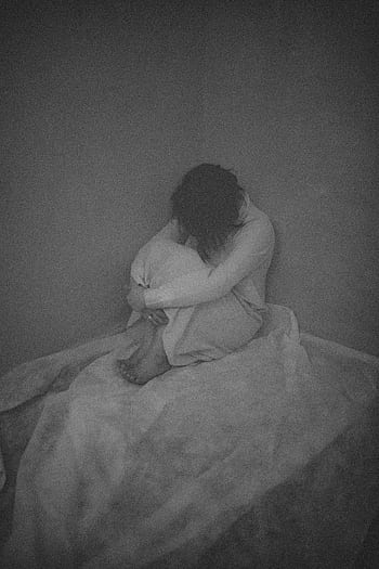 A black and white capturing a woman sitting alone, conveying deep emotions. HD phone wallpaper