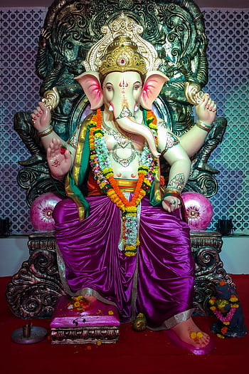 Colorful statue of Hindu deity Ganesha adorned with flowers, symbolizing prosperity and wisdom. HD phone wallpaper