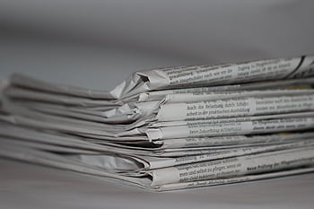 A close-up of folded newspapers, perfect for news or journalism themes. HD wallpaper