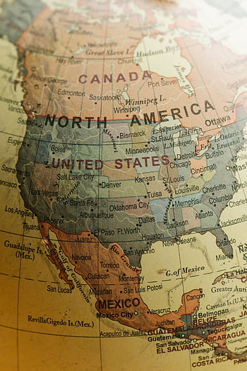 Detailed close-up view of North America on a vintage globe showing countries and cities. HD phone wallpaper