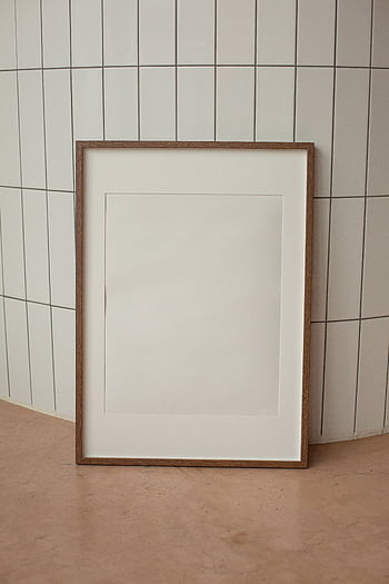 Elegant minimalist frame leaning on a tiled wall, perfect for interior decor ideas. HD phone wallpaper