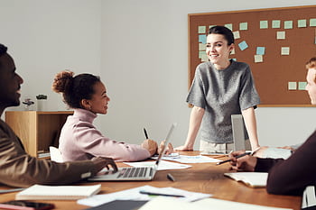 Business team collaborating in a modern office setting with diverse colleagues. HD wallpaper
