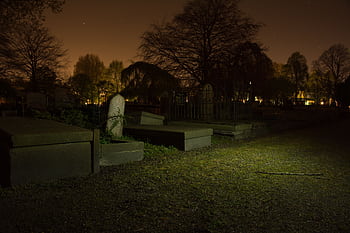 Mysterious graveyard at night with tombstones and trees. Perfect for spooky themes. HD wallpaper
