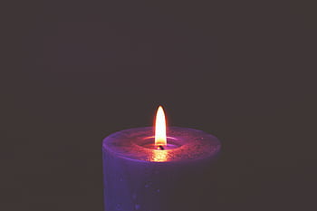 A soothing candle flame glowing in darkness, creating a peaceful mood. HD wallpaper
