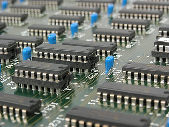 Detailed macro shot showcasing integrated circuits and components on electronic motherboard. HD wallpaper