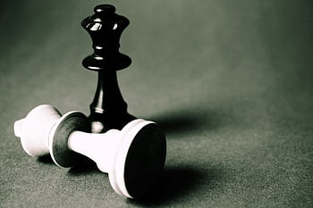 Close-up of chess pieces illustrating strategy and challenge in black and white tones. HD wallpaper