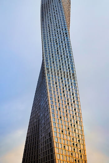 The iconic Cayan Tower's twisting design set against a serene Dubai sky. HD phone wallpaper