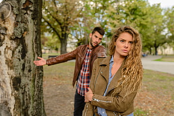 A man and woman in a heated argument outdoors, expressing emotions. HD wallpaper