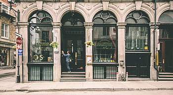 A historic restaurant facade with arched windows in a city street. HD wallpaper