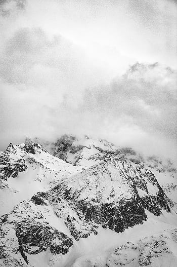 Dramatic monochrome of snow-covered mountain peaks enveloped in fog. HD phone wallpaper