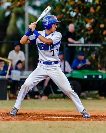 Teen baseball player in uniform ready to swing during a game on a grassy field. HD phone wallpaper