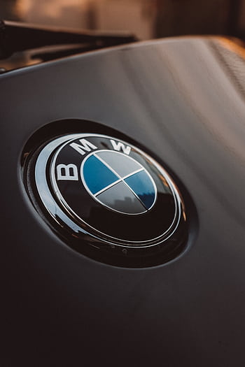 Close-up of a shiny BMW logo on a luxury car, emphasizing modern design. HD phone wallpaper