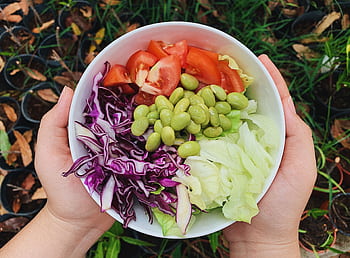 A vibrant bowl of fresh garden salad featuring tomatoes, edamame, and cabbage. Perfect for healthy dining. HD wallpaper